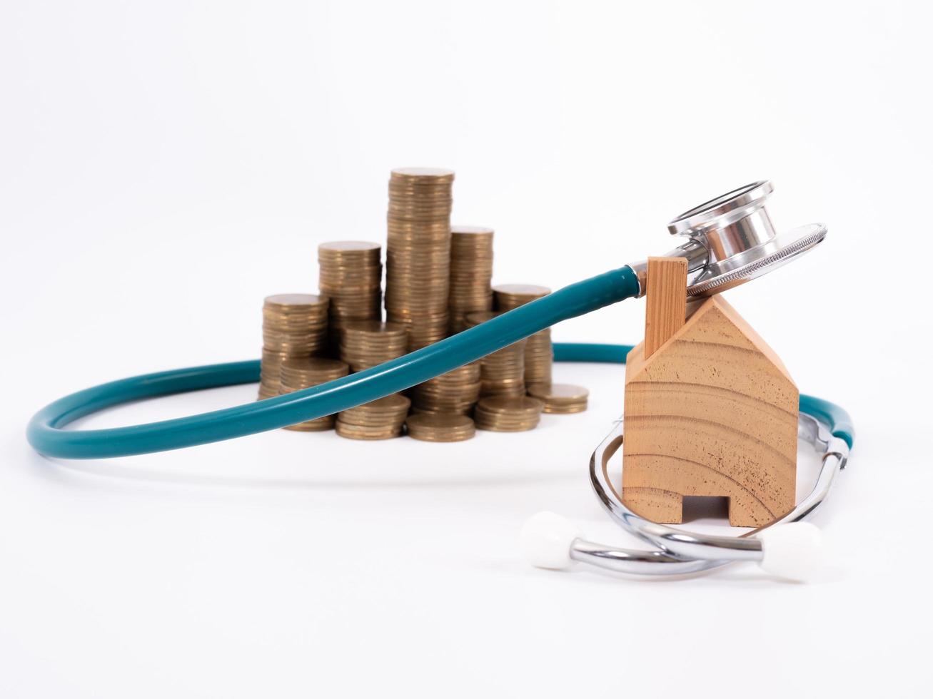 Check up house and investment concept. Stethoscope with miniature house and money photo