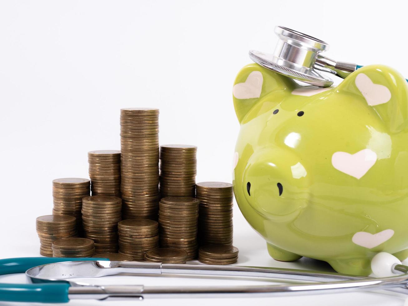 piggy bank with coins and stethoscope photo