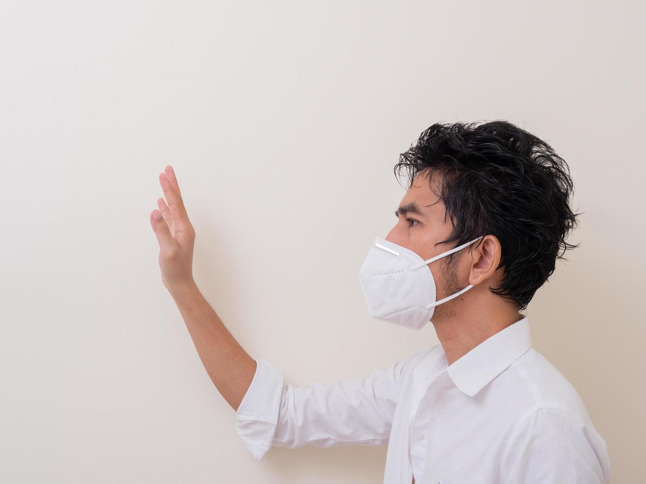Asian young man in white shirt and medical mask to protect COVID-19 photo