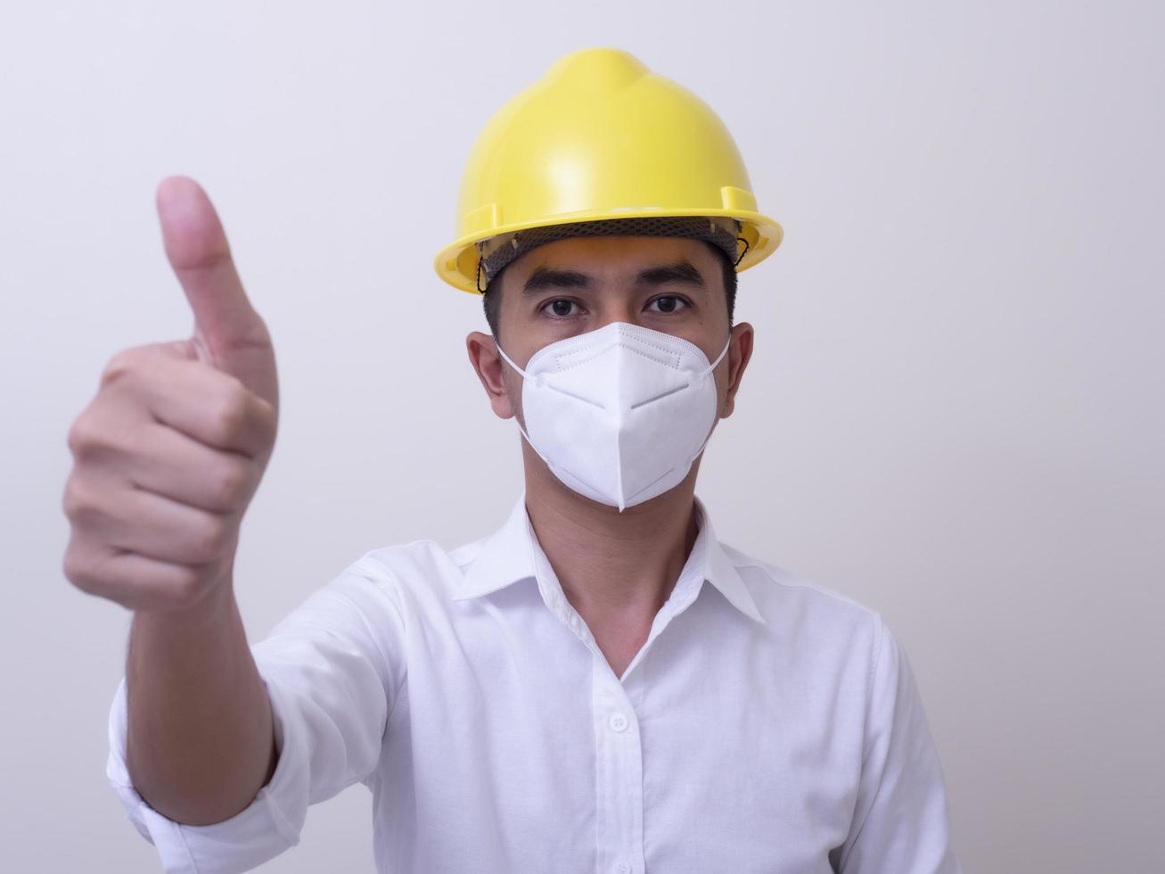 Asian industrial workers wear yellow hard hats, wear protective masks for their health photo
