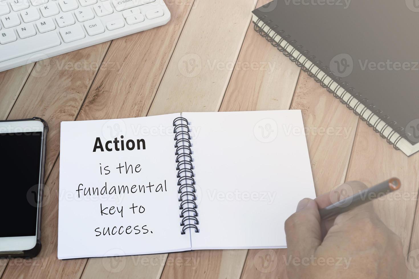 Action is the fundamental key to success, motivational quote on note book. photo