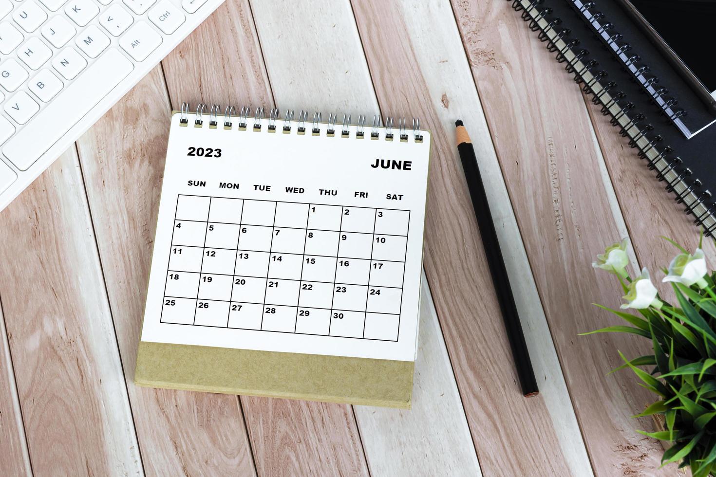 Calendario blanco de junio de 2023 en escritorio de madera. endecha plana foto