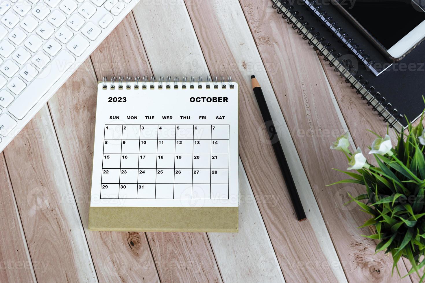 White October 2023 desk calendar on wooden desk. Directly above. Flat lay. photo