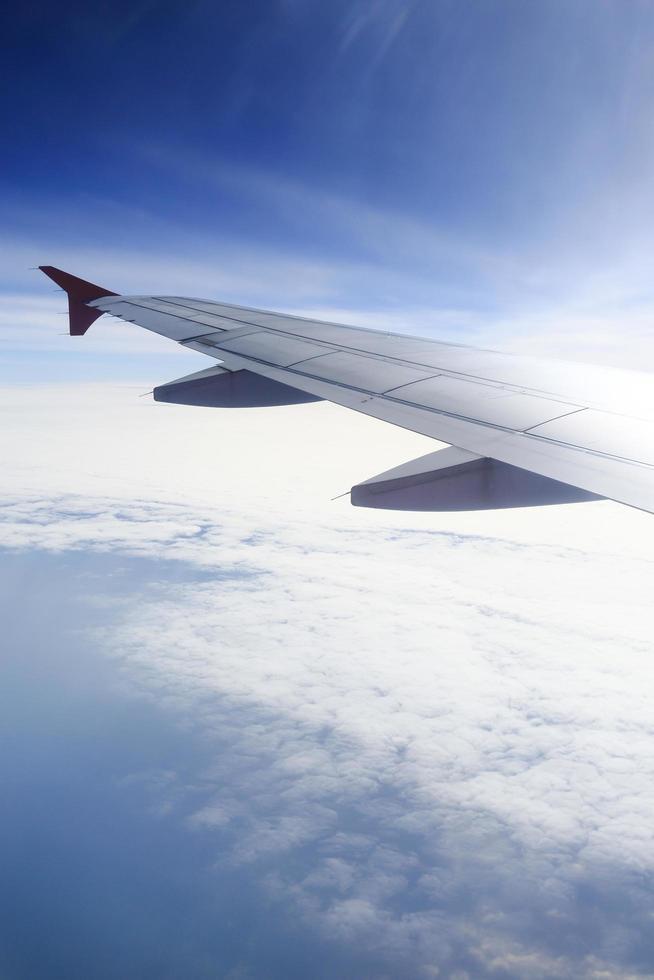 Wing of an airplane flying above the clouds. photo