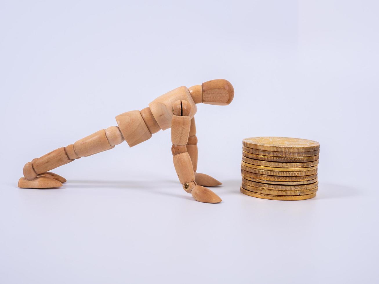 Wooden puppet Rolls of coins for finance and business concept photo