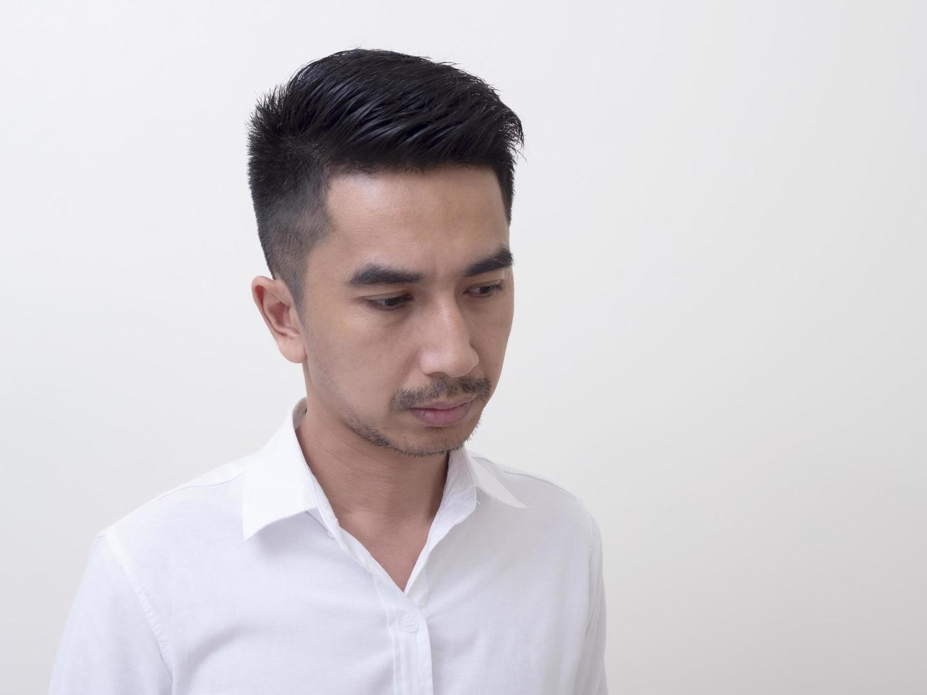 Young Asian man isolated on white background looking sideways photo