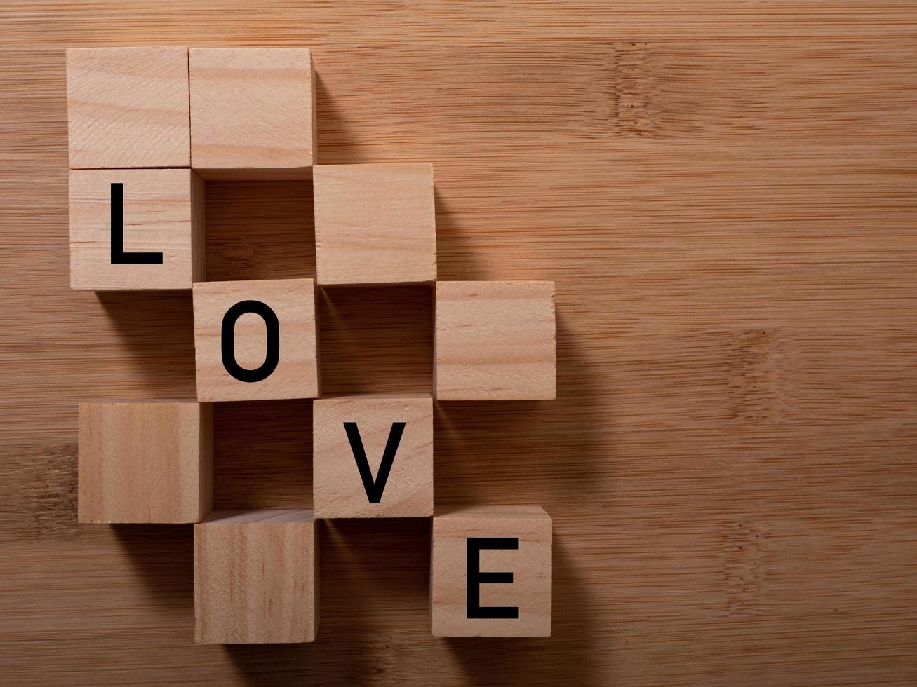 Word Love on wooden cubes with red heart, close-up near white background valentine concept photo