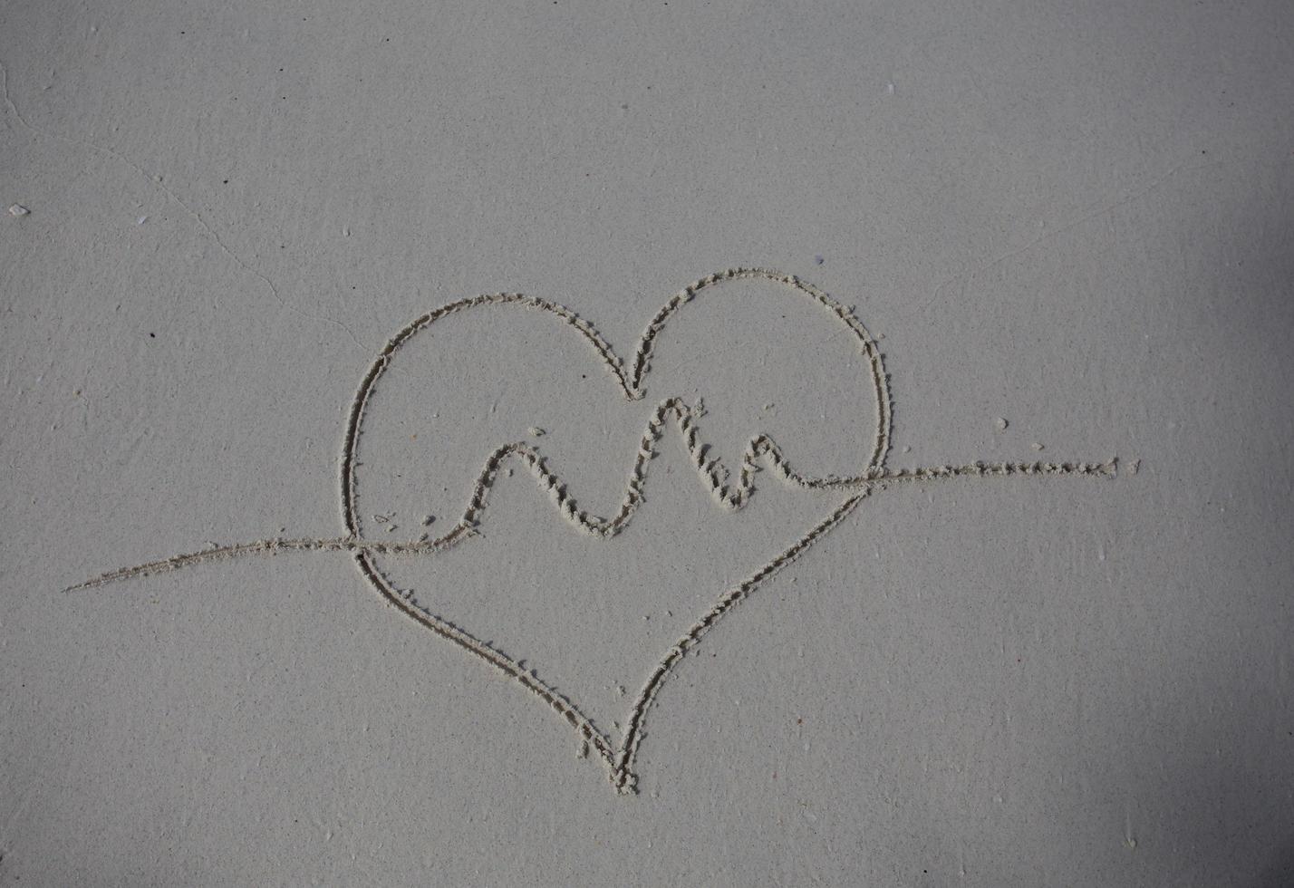 hearts drawn on the sand of a beach photo