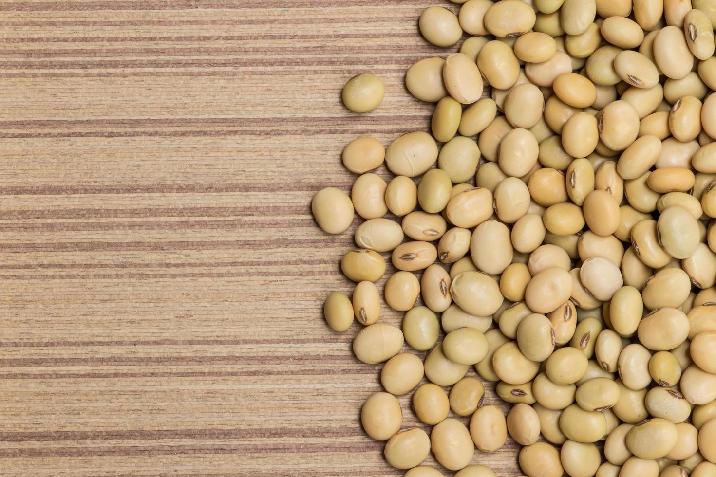 Dry soybeans on wooden board photo