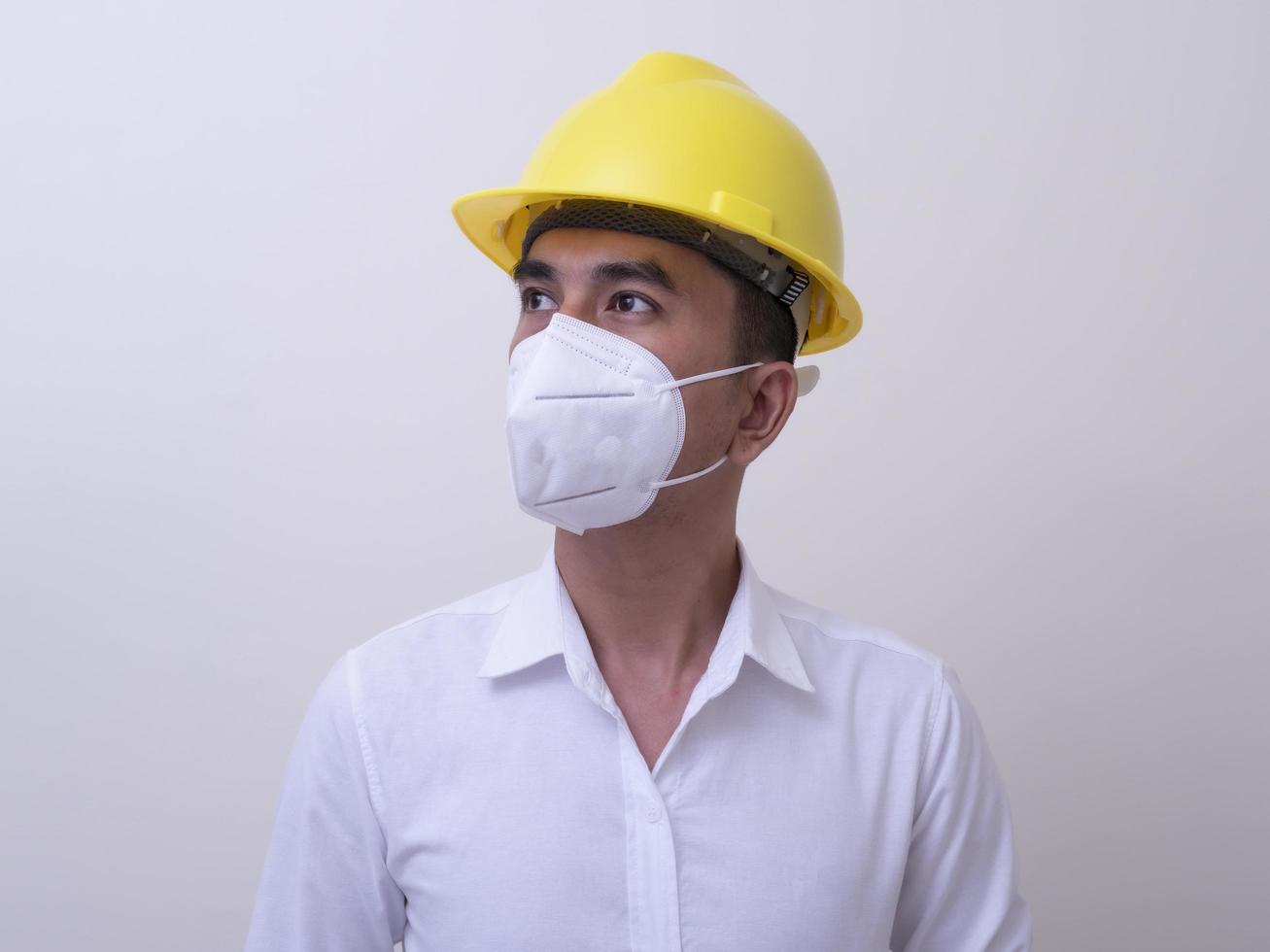 Asian industrial workers wear yellow hard hats, wear protective masks for their health photo