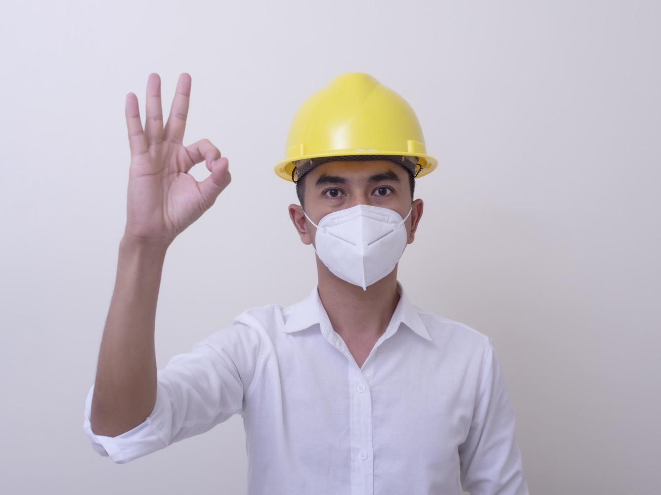 Asian industrial workers wear yellow hard hats, wear protective masks for their health photo