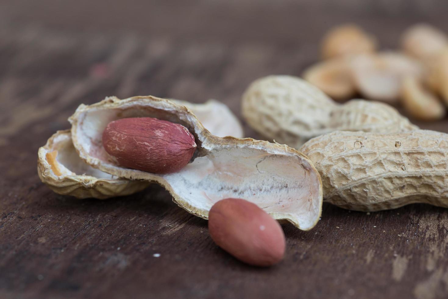 Peanuts in shells on wood background photo