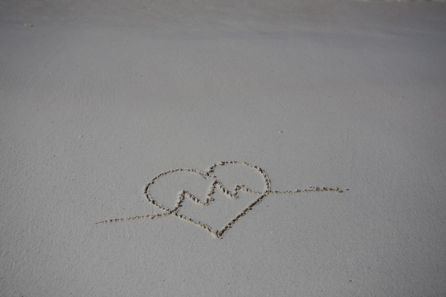 hearts drawn on the sand of a beach photo