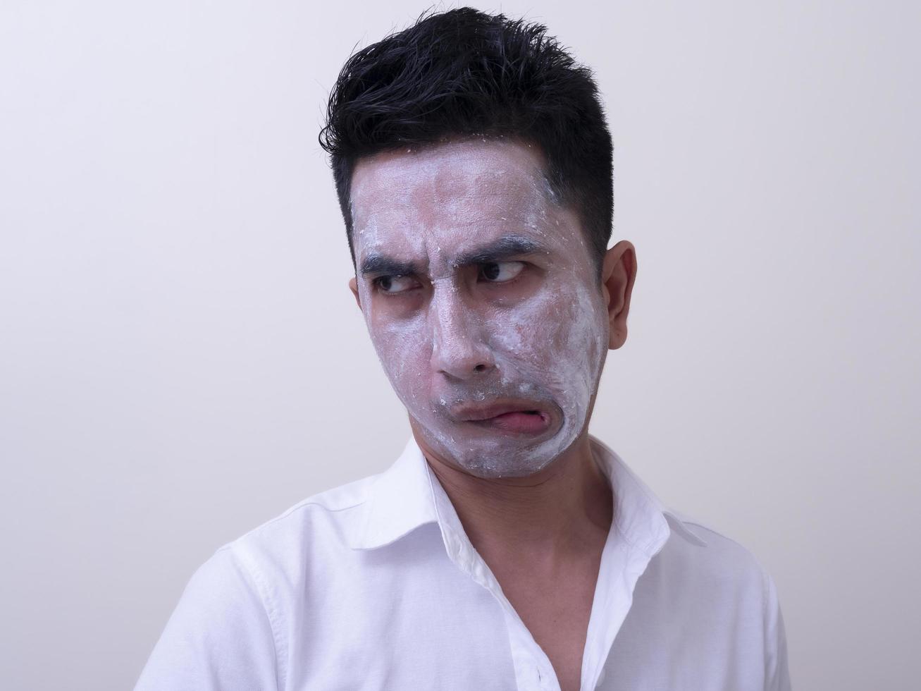 Asian handsome young man applying cream at his face with smiley face, Skin care concept photo