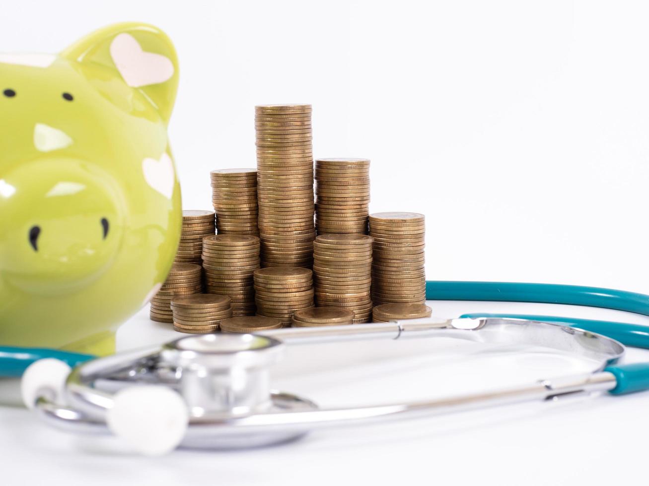 piggy bank with coins and stethoscope photo