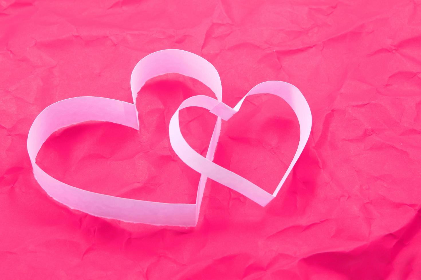 Paper hearts on pink background photo