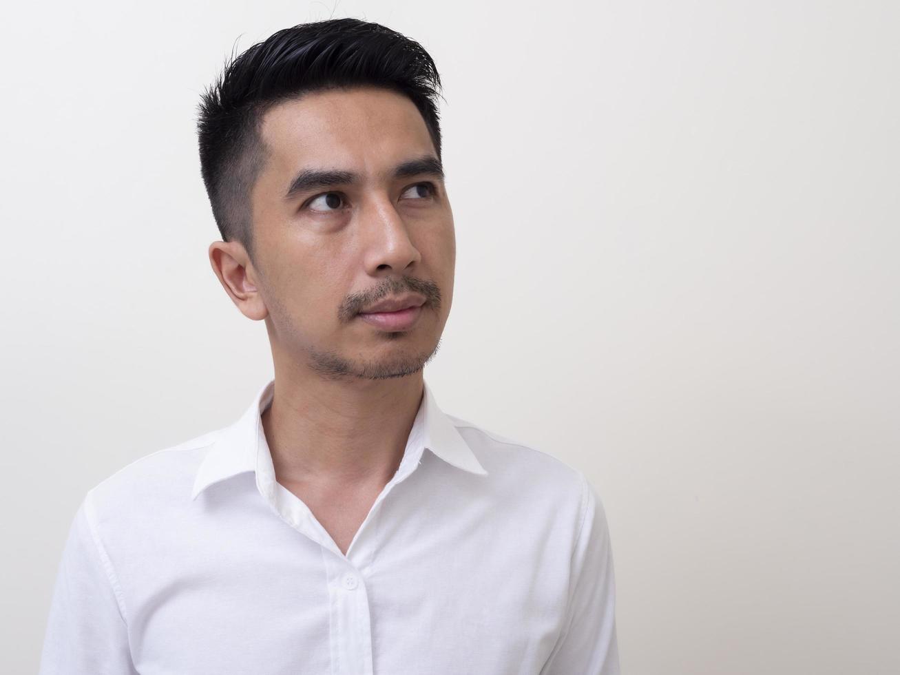 Portrait of Young funny Asian man with white shirt looking at camera photo