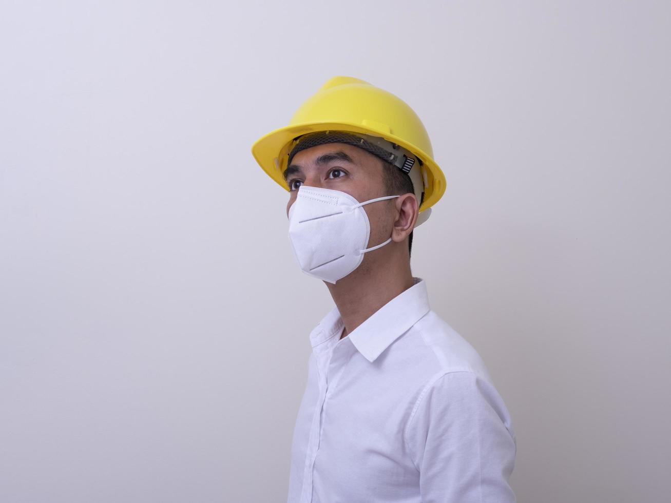 Asian industrial workers wear yellow hard hats, wear protective masks for their health photo
