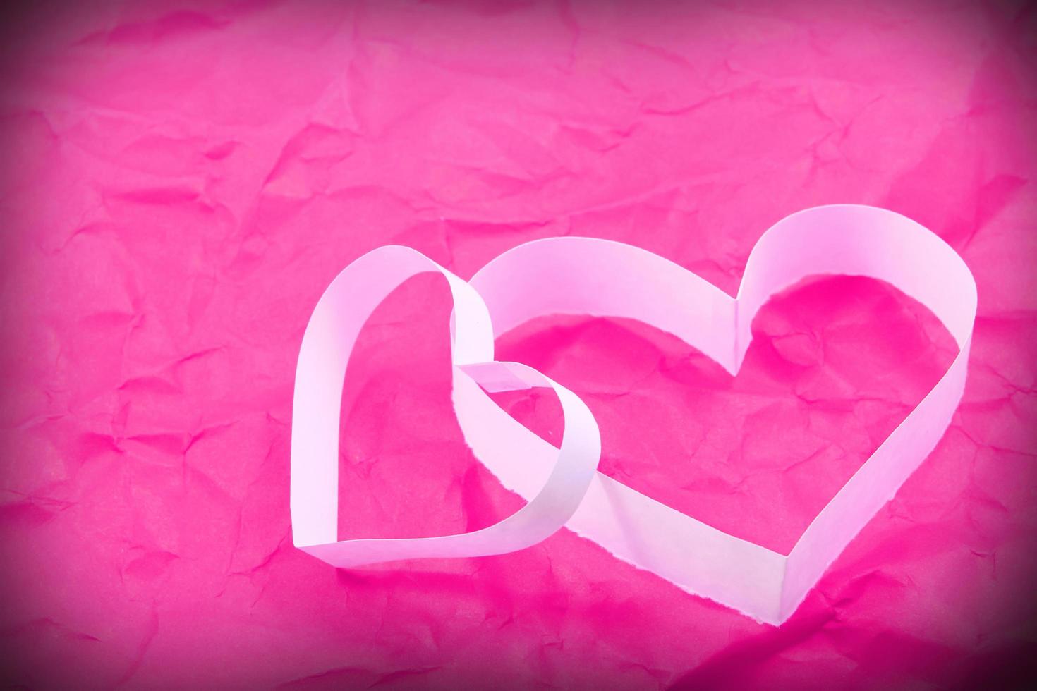 Paper hearts on pink background photo