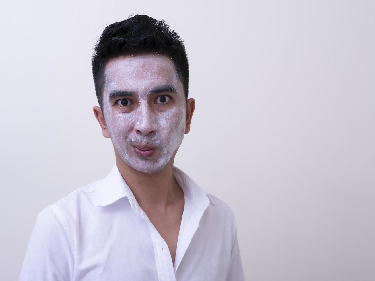 Asian handsome young man applying cream at his face with smiley face, Skin care concept photo