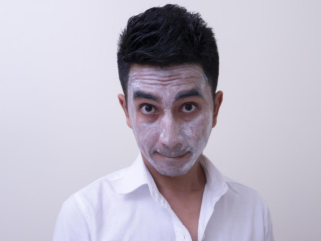 Asian handsome young man applying cream at his face with smiley face, Skin care concept photo