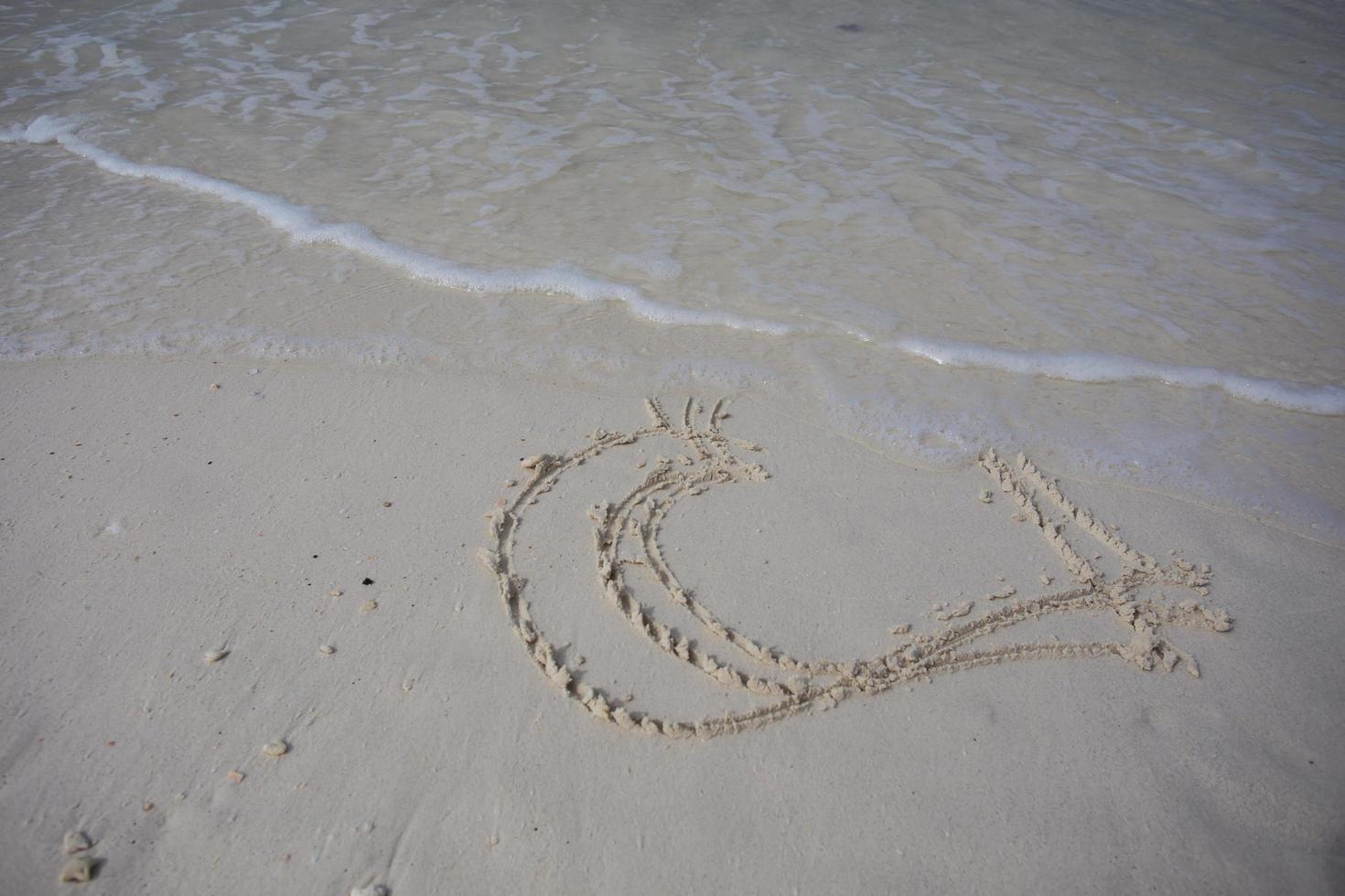 hearts drawn on the sand of a beach photo