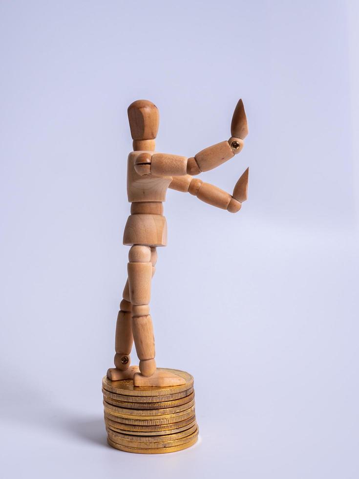 Wooden puppet Rolls of coins for finance and business concept photo