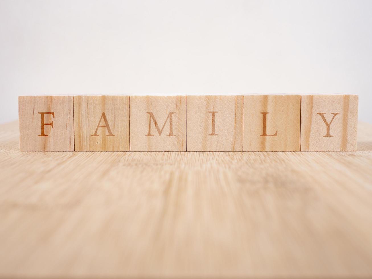 Family word written on wood block on wooden background photo