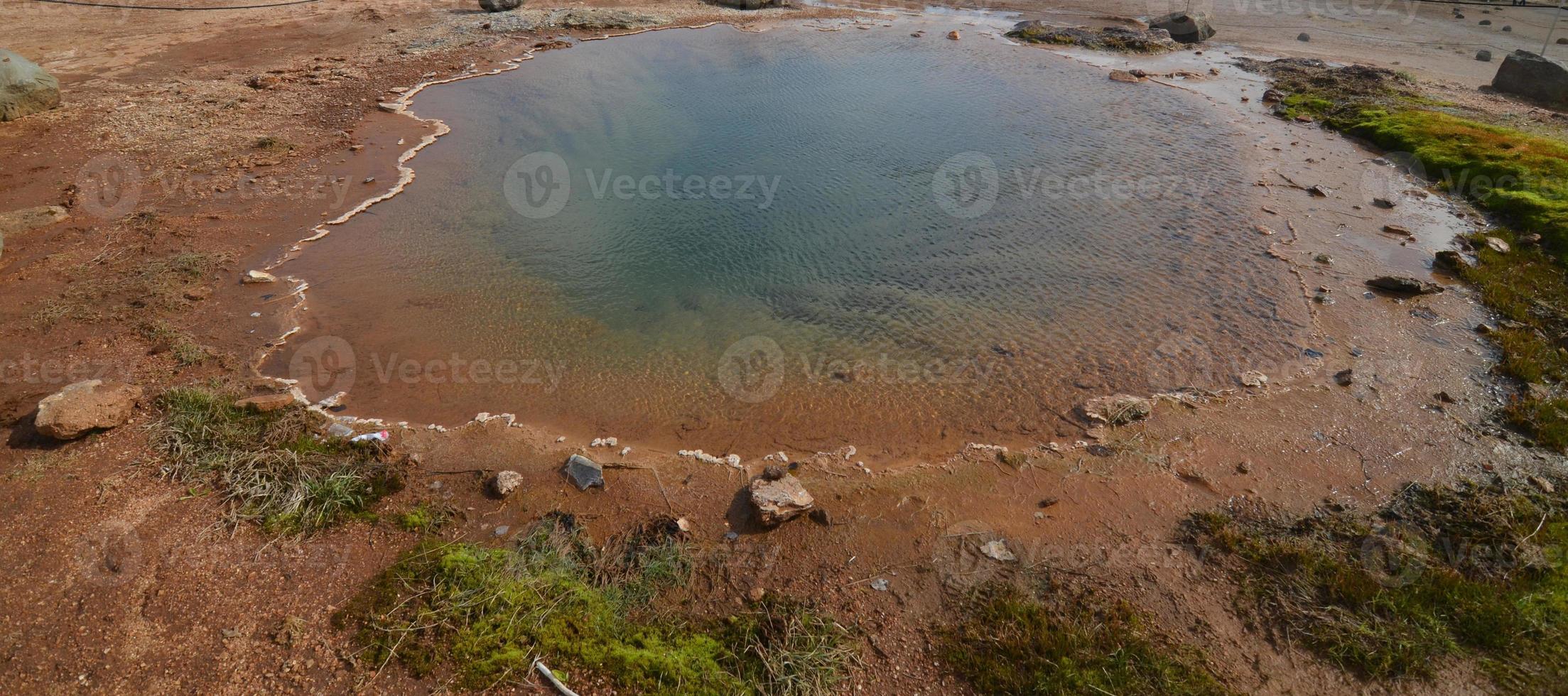 gran fuente termal en un campo con muchos depósitos minerales foto