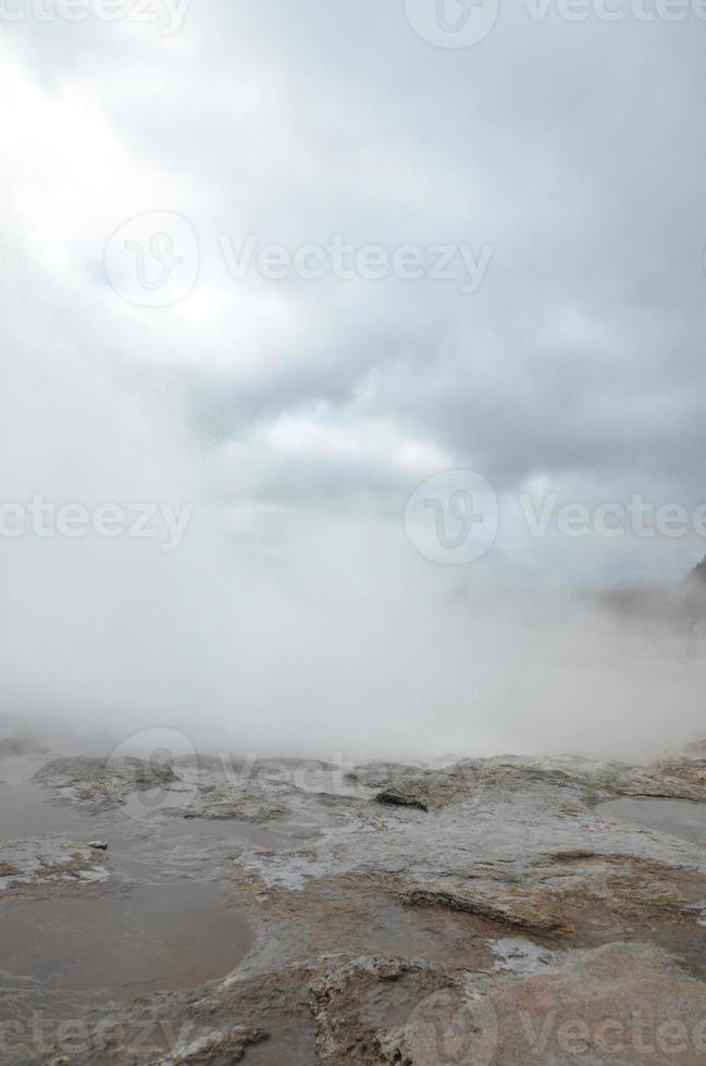 Blue sky breaking out of the clouds with a steaming geyser photo