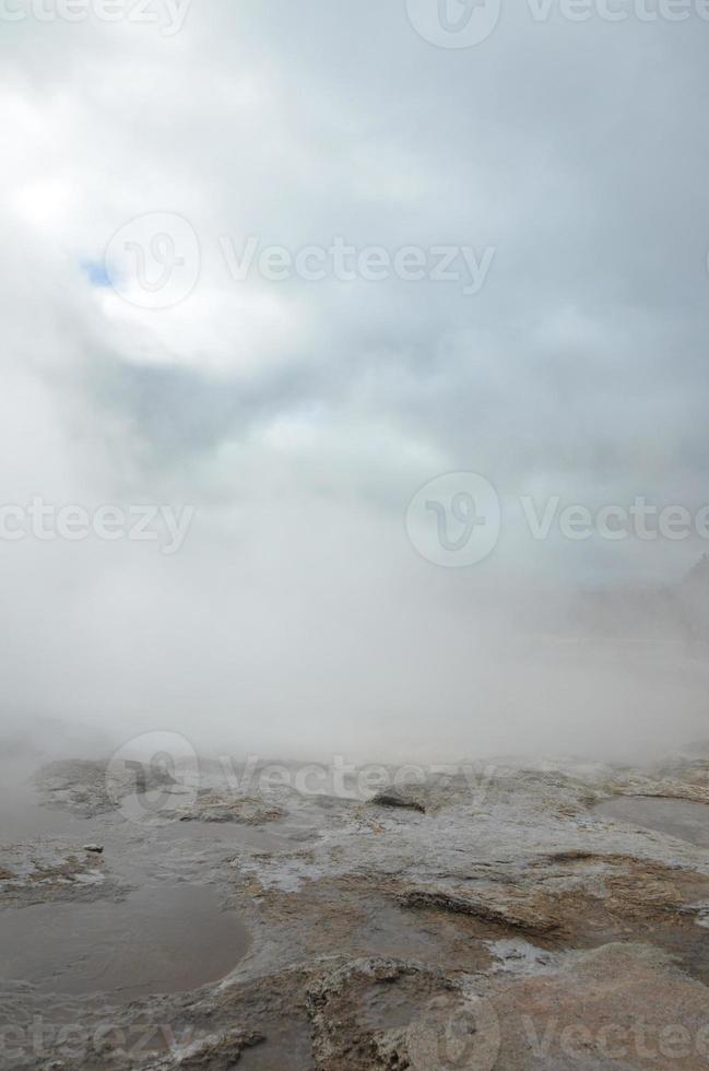 Beautiful cloudy skies with a steaming geyser in Iceland photo