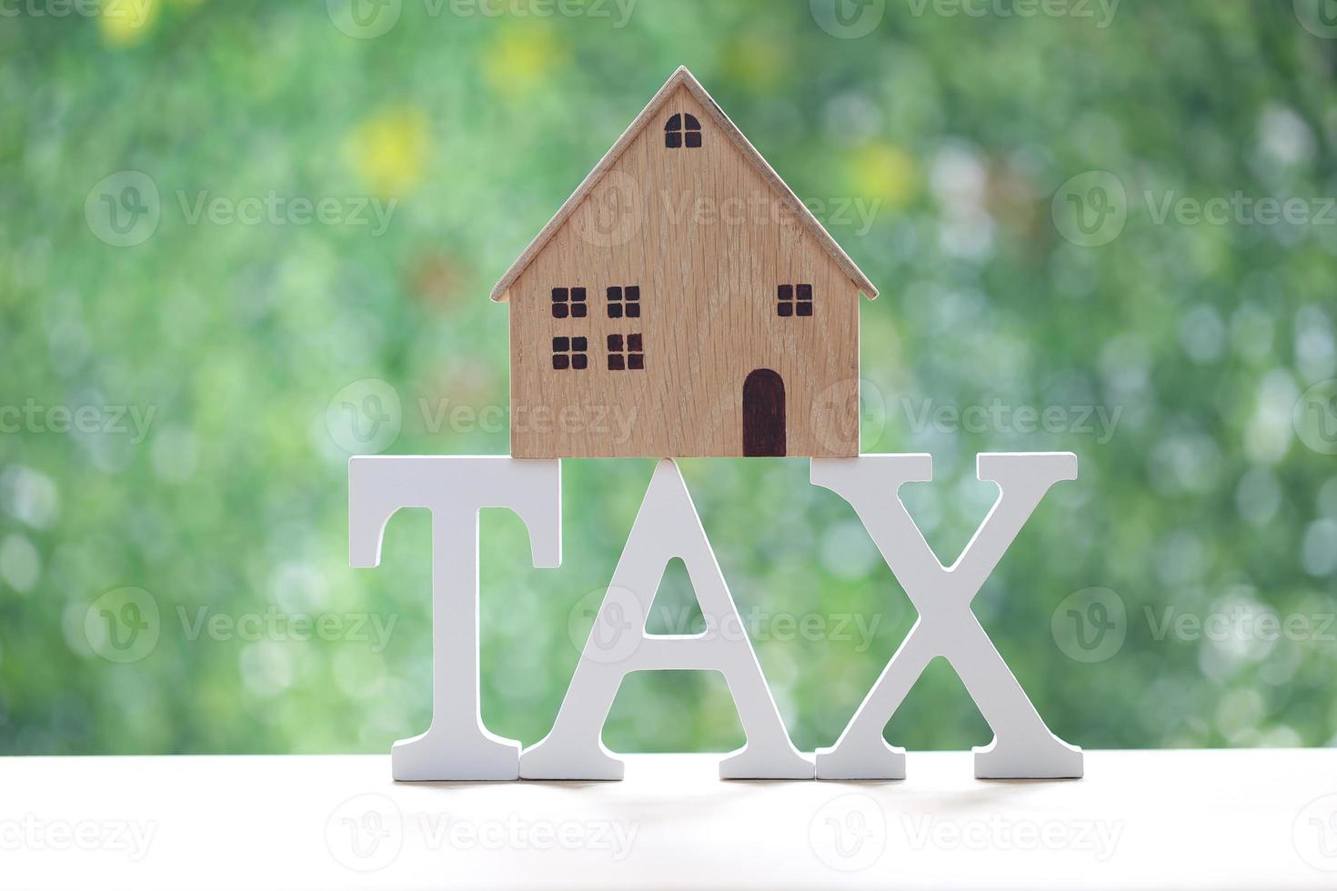 Estate tax,Model house on tax word and calculator on natural green background,Business investment and Property tax concept photo