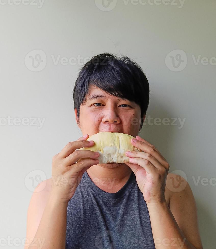 los jóvenes asiáticos comen deliciosamente durian. las frutas con olor son populares en tailandia. foto