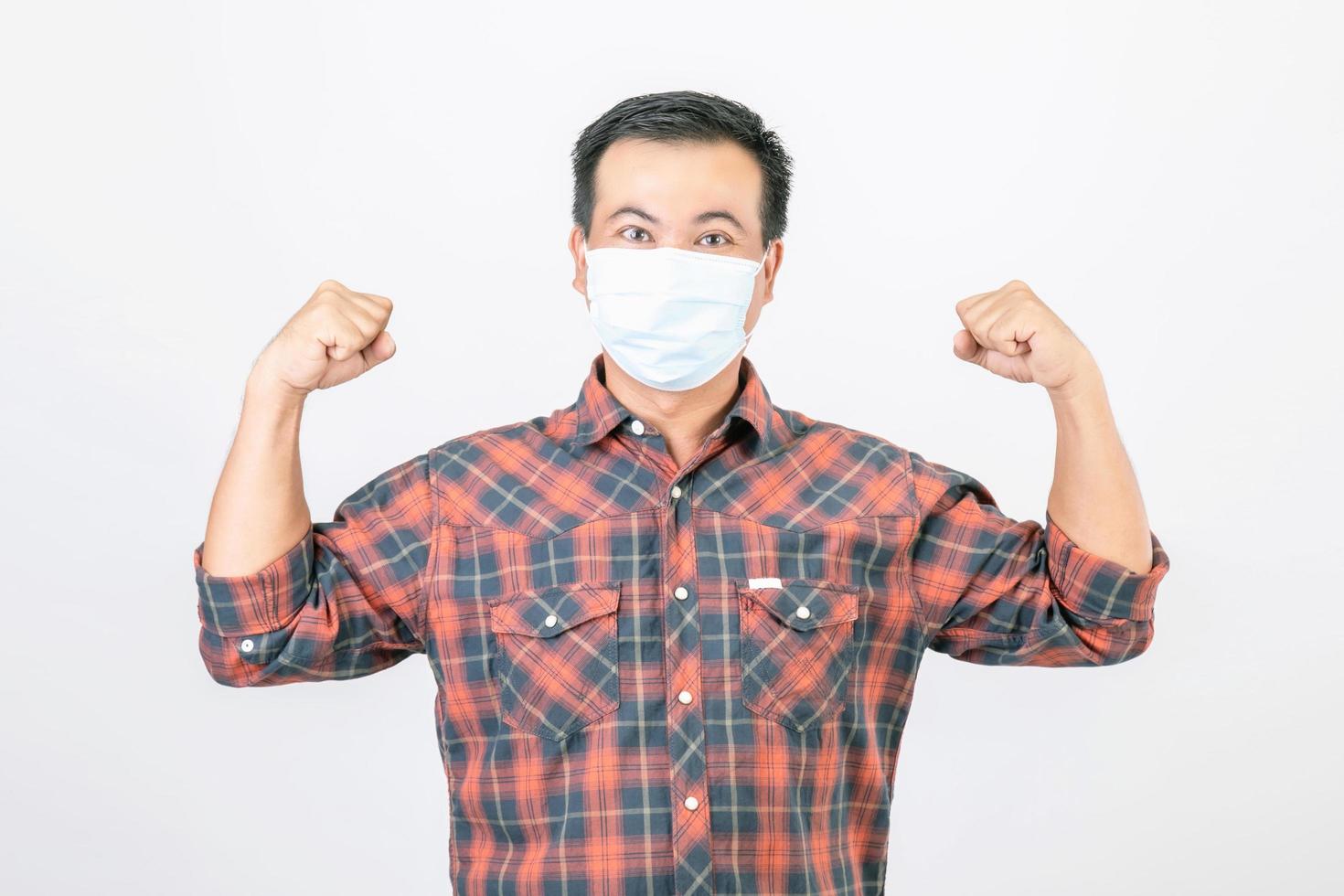 Passed bad situation concept, Asian man wearing protective face mask in action of glad, victory or very happy isolated on grey photo