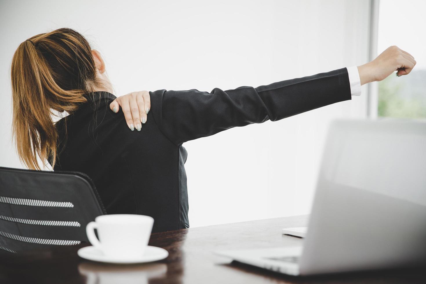 Young asian woman are tired from work, sit in a chair, stretch photo