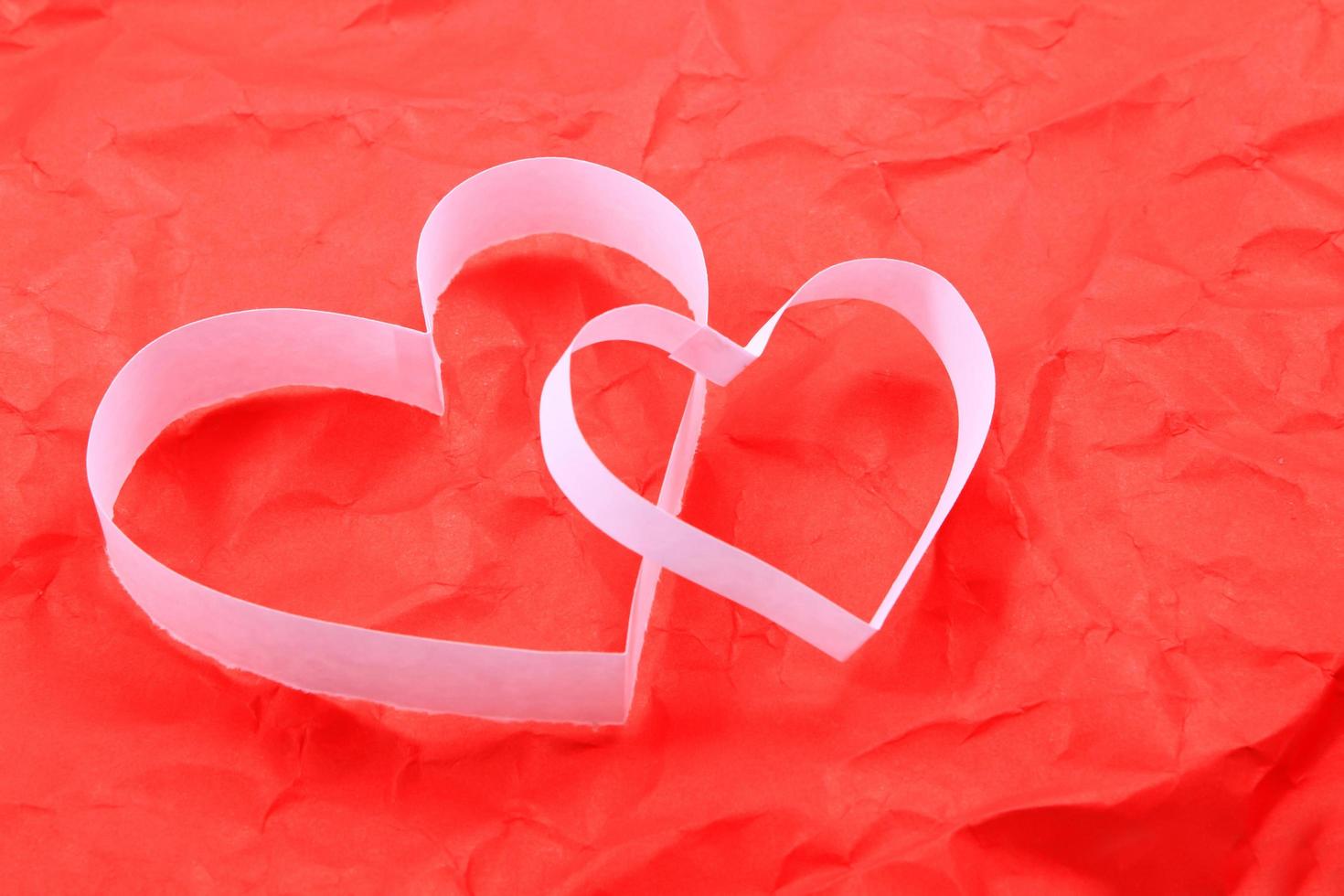 Paper hearts on red background photo