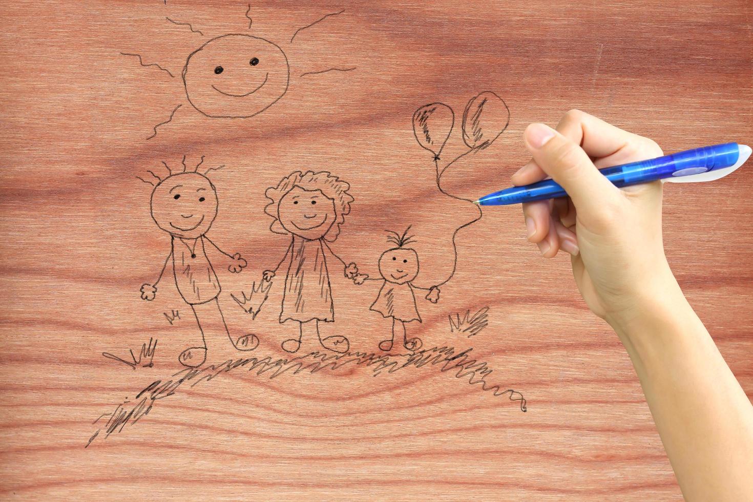 Hand drawing a happy family on wood photo
