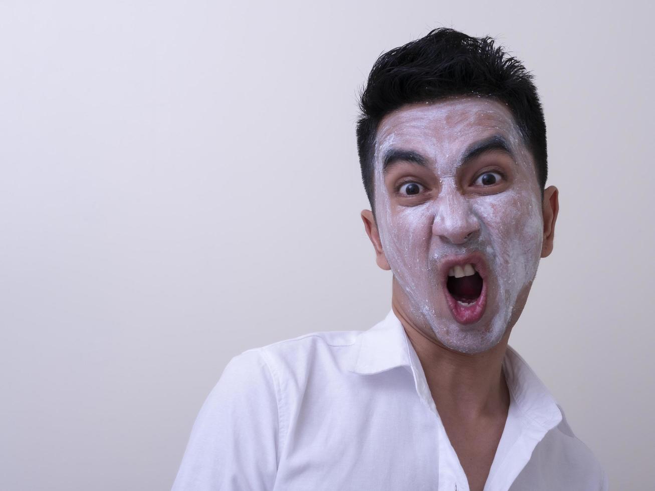 Asian handsome young man applying cream at his face with smiley face, Skin care concept photo
