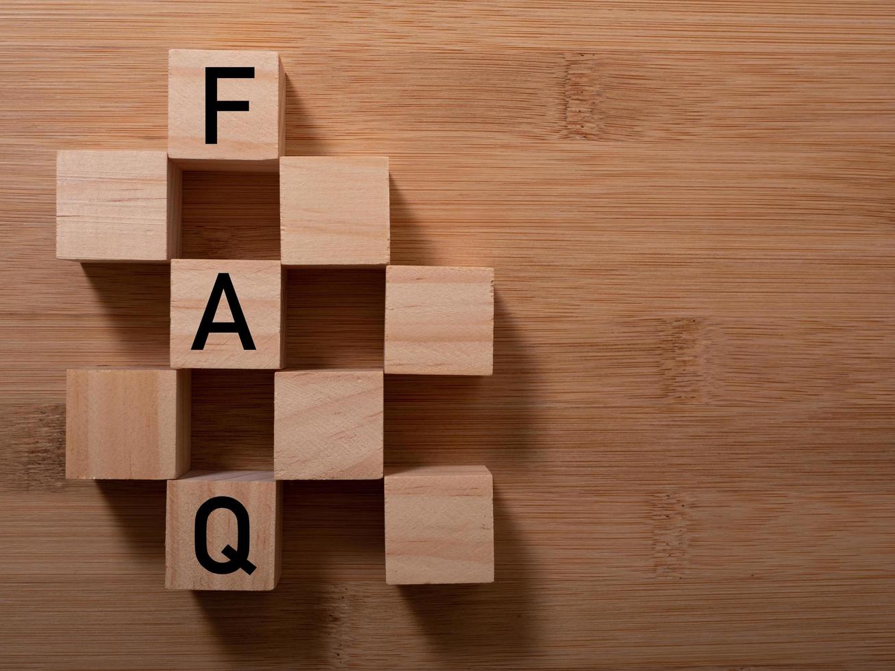 closeup of wooden word on wooden table background concept - FAQ photo