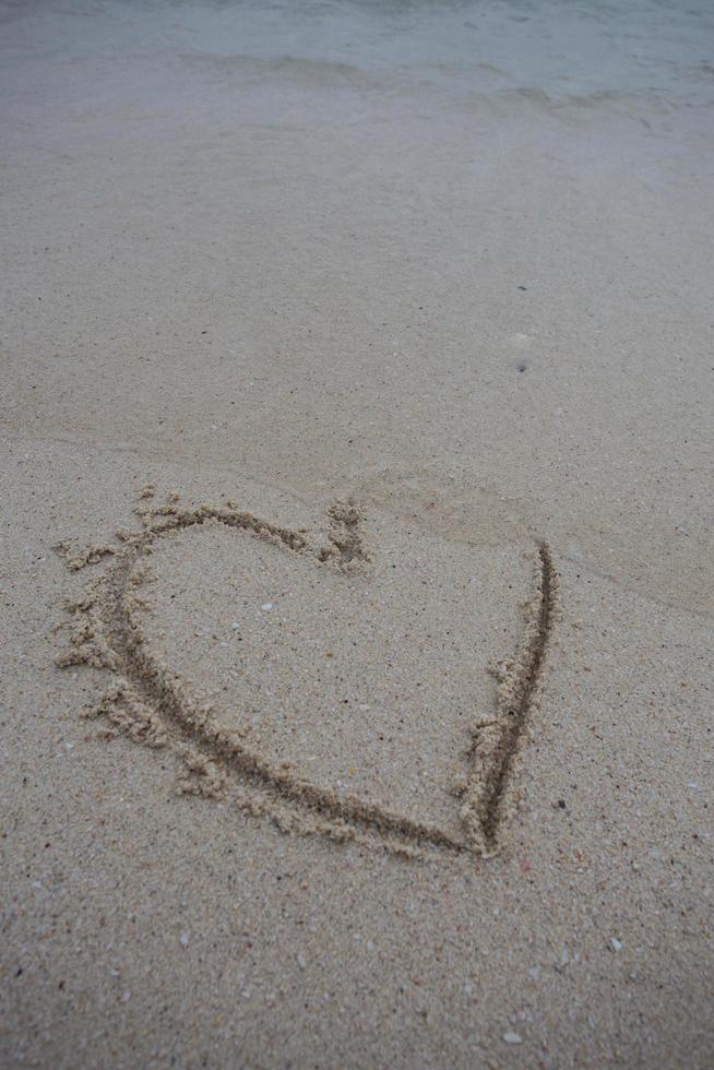 hearts drawn on the sand of a beach photo