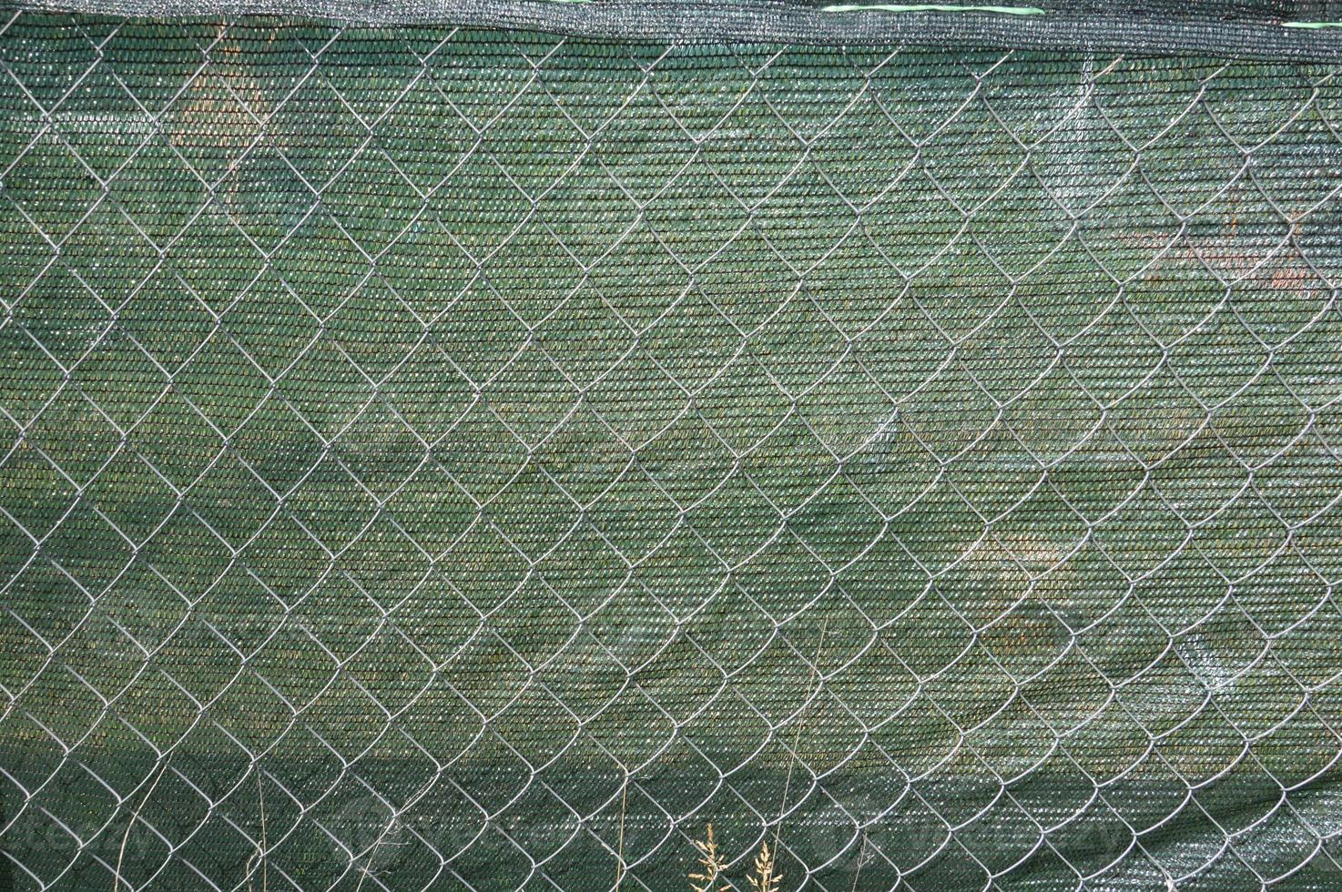 Installation of a shading net on a chain-link fence photo