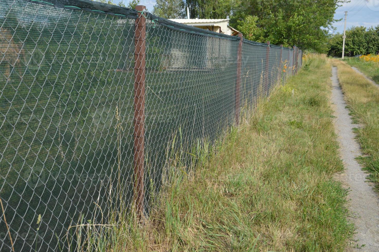 Installation of a shading net on a chain-link fence photo