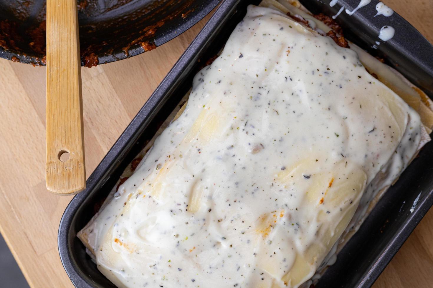 lasaña lista para ser horneada en el horno. vista desde arriba. capas de carne y pasta y salsa bechamel. foto