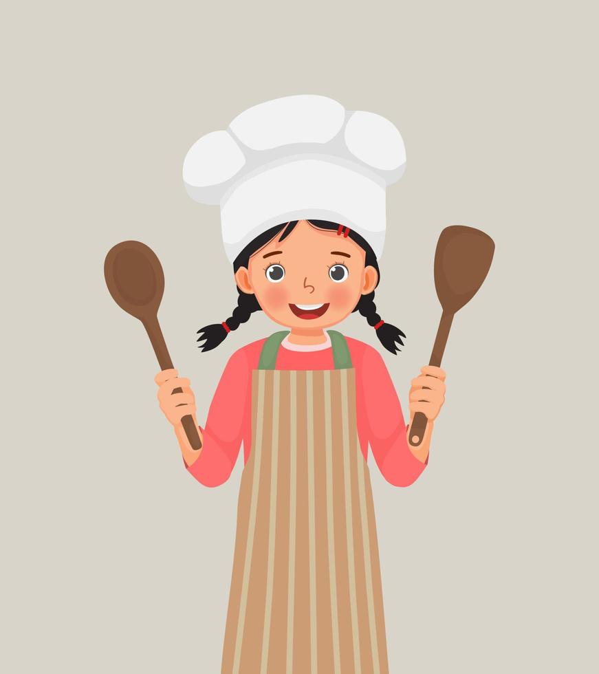 linda niñita con sombrero de chef y delantal sosteniendo espátula de utensilio de cocina y cuchara de cucharón vector