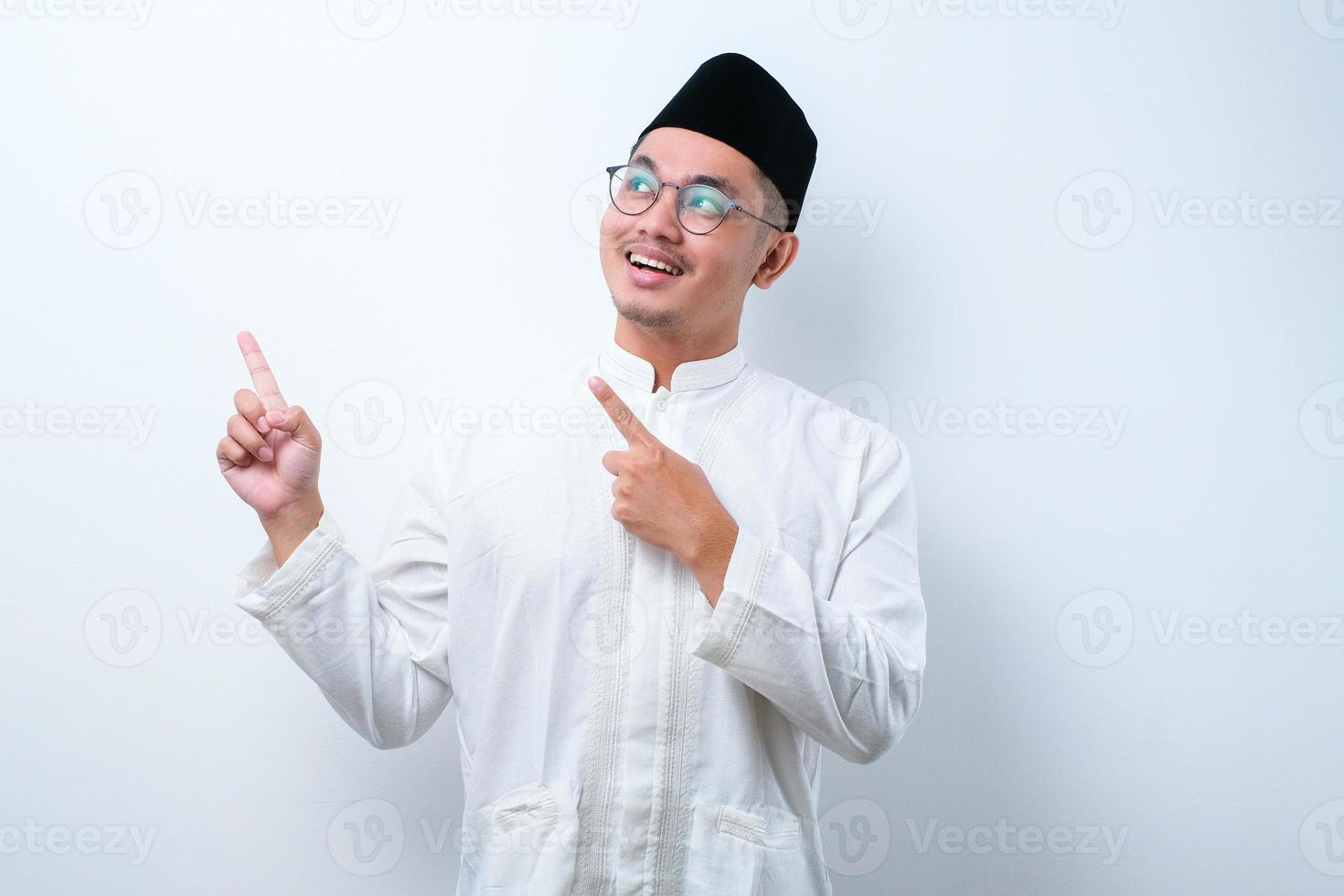 Asian muslim mas pointing something on his side with his both hand photo
