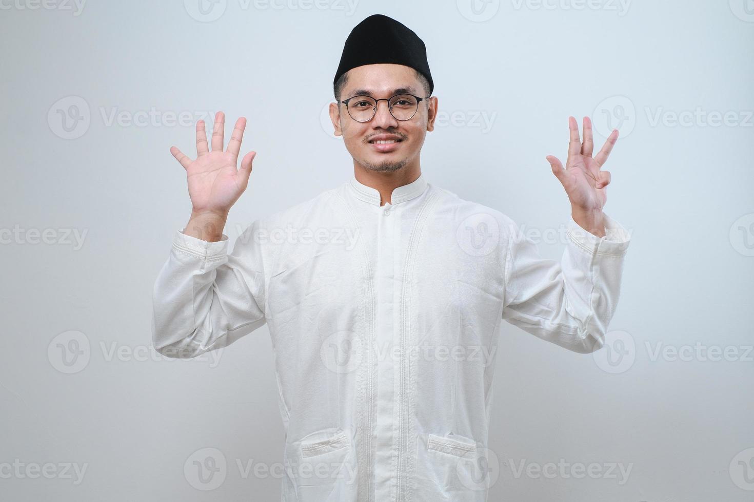 Asian muslim man wearing casual clothes showing and pointing up with fingers number nine while smiling confident and happy photo