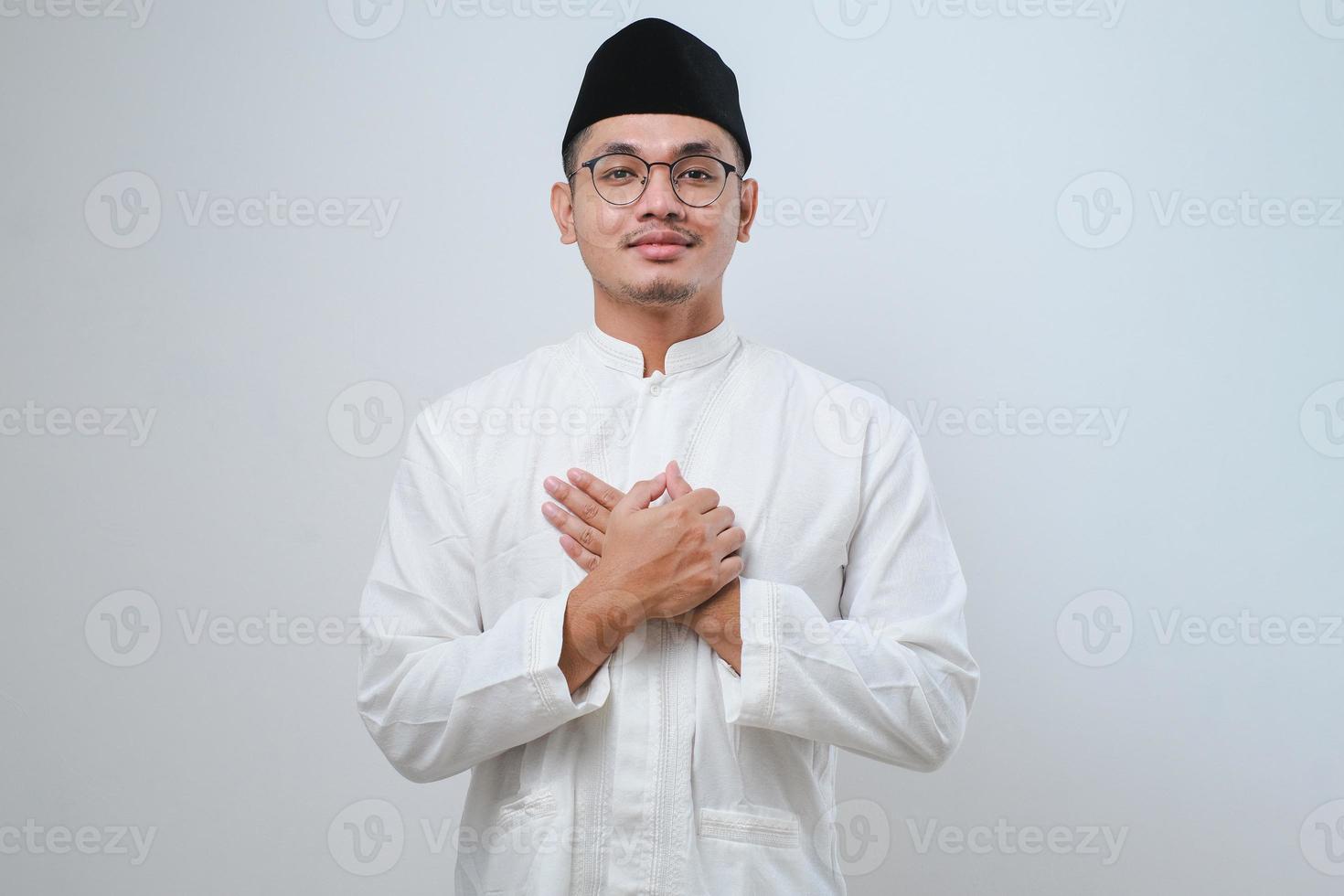 Asian muslim man wearing casual clothes smiling with hands on chest with closed eyes and grateful gesture on face photo