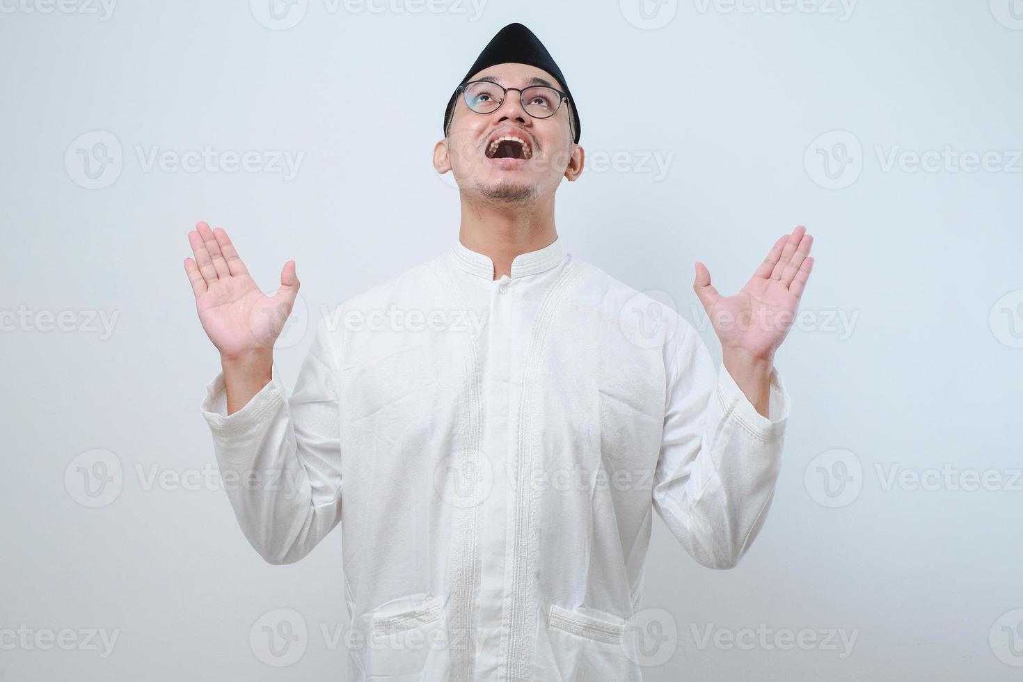 Asian Muslim man protecting themselves with outstretched hands from something getting to them from above photo
