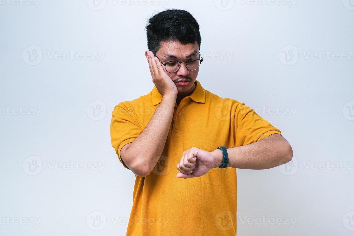 Handsome asian an wearing casual clothes looking at the watch time worried, afraid of getting late photo