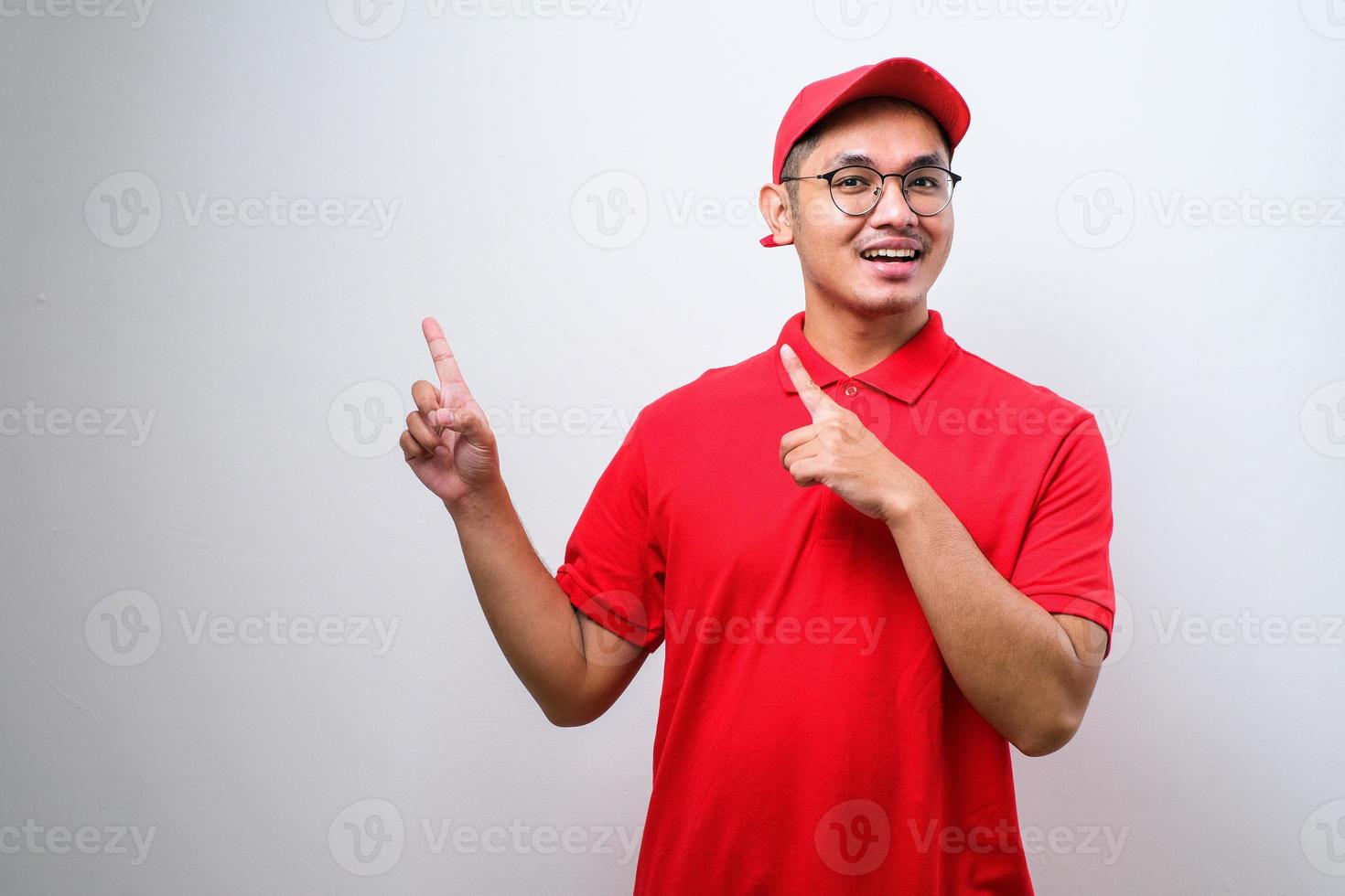 Young handsome chinese delivery man  pointing with hand and finger to the side looking at the camera. photo